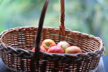 Poster - A fruit basket filled with fresh apples placed on a wooden table.