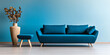 © JuanM - Stylish living room featuring a teal couch, matching stool, and modern decor against a light blue wall