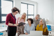 © Halfpoint - Teacher explaining senior students how to start their own business. Elderly people attending computer and technology education class. Entrepreneurship program for seniors.