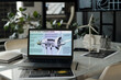 © TrueFrame Collective - Workplace of modern architect with visual template of windmill turbine on laptop screen in office