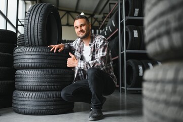 Wall Mural - Man chooses winter car tires in the auto shop