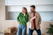 © DimaBerlin - Loving family couple have fun on moving day. Happy, overjoyed man and woman smiling dancing in empty kitchen with cardboard boxes in new purchased apartment. Pleasure of fulfilling dream goal together