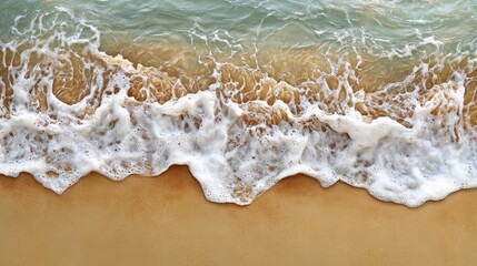 a dynamic top view of waves crashing onto the shore, with frothy white water blending into the smooth, golden sand.