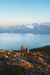 © EVERST - Couple man and woman enjoying mountains and fjord landscape, active family adventure vacations - friends hiking with backpacks in Norway together exploring Lyngen Alps, healthy lifestyle trip outdoor