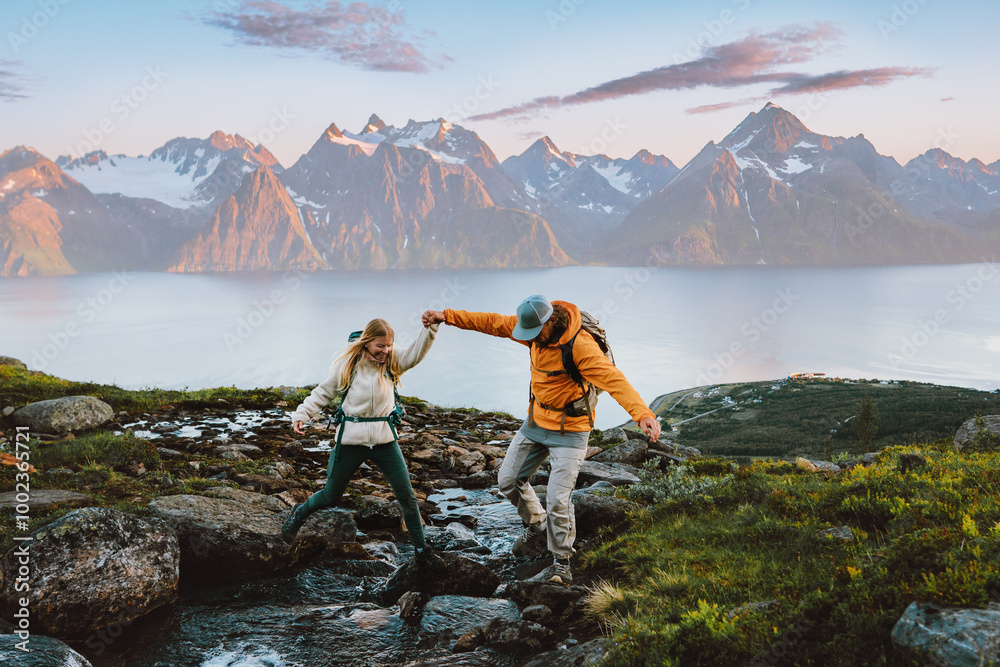 Couple hiking in Norway man helps woman cross river in mountains ...