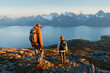© EVERST - Couple man and woman hiking with backpacks in Norway mountains together exploring Lyngen Alps healthy lifestyle outdoor active family vacations adventure trip, friends enjoying fjord view