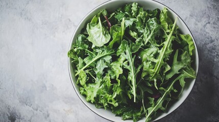 Wall Mural - a healthy bowl of fresh leafy vegetables, including spinach, kale, and arugula, served with a light lemon vinaigrette.