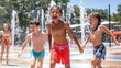 © Luxetify - Three children are laughing and playing in a water fountain on a sunny day.