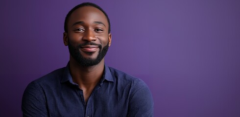 Sticker - A portrait of a young man with a beard, smiling slightly. He is wearing a blue shirt and standing in front of a purple background.