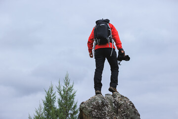 Wall Mural - Successful hiker with camera on mountain top