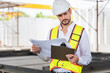 © Poguz.P - Foreman worker on a construction site, Engineer man in hardhat working at construction site.