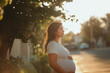 © Running opossum - Pregnant woman is touching her belly while enjoying a moment of peace in the golden light of the setting sun
