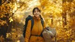 © Eric - A portrait of an East Asian woman walking along a narrow path in a forest with golden autumn leaves.