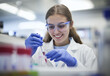 © mafsdisseny - A young woman wearing blue rubber gloves and white lab coat is working in the laboratory.