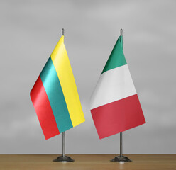 Table flags of Italy and Lithuania on a gray blurred background