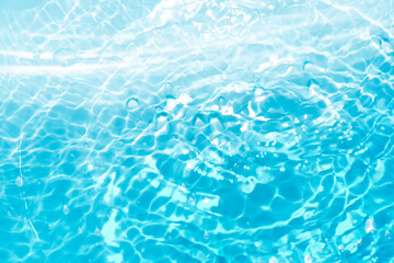 Blue water with ripples on the surface. Defocus blurred transparent blue colored clear calm water surface texture with splashes and bubbles. Water waves with shining pattern texture background.