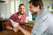 © Marko Geber - Gay couple enjoying lunch together at home