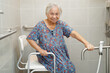 © manassanant - Asian elderly old woman patient use toilet support rail in bathroom, handrail safety grab bar, security in nursing hospital.