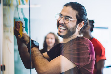 Wall Mural - Laughing man writing on glass board