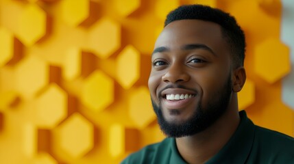 Poster - Portrait of a smiling man with a beard, standing in front of a yellow geometric background.