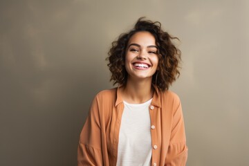 Sticker - Portrait of a joyful woman in her 20s wearing a chic cardigan over blank studio backdrop