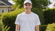 © QuoDesign - Teenage boy wearing white t-shirt and white baseball cap standing in the garden