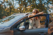 © olezzo - Happy woman driver traveling by car in forest enjoying freedom and nature