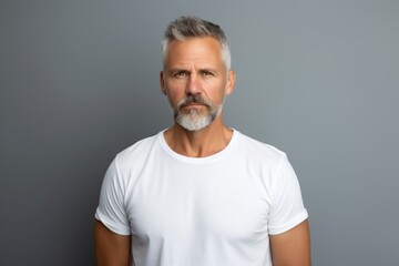 Wall Mural - Portrait of a tender man in his 50s dressed in a casual t-shirt in plain white digital canvas