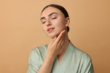 Canvas Print - Face massage. Beautiful young woman with healthy skin on beige background