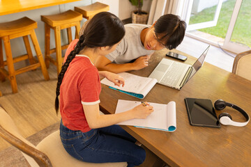 studying together, two students using laptop and notebooks table