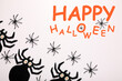 © New Africa - Happy Halloween text and scary spiders on white background, top view. Greeting card