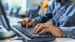 © Mrzproducer - professional working on a computer, typing on a keyboard with focus and dedication in a modern office environment.