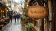 © aicandy - A charming cobblestone street with a vintage wooden restaurant sign, blurred background of people walking and old-fashioned buildings with warm lighting