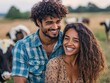 © DKPhoto - A joyful couple stands close together, beaming with happiness as they enjoy a sunny day on a farm surrounded by cows, embracing a simple, pastoral lifestyle.