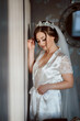 © Vasil - A woman in a white gown with a tiara on her head. She is leaning against a wall