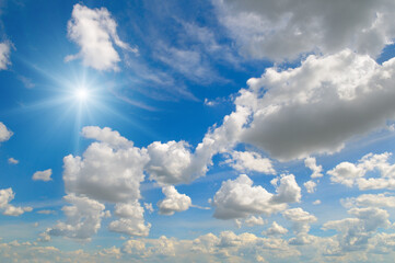 Blue sky with clouds and bright sun.