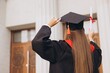 © anatoliycherkas - Rear View Young Female Graduate Celebrating Achievement with Diploma at University Campus in Bright Sunshine