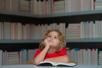Fototapete - Back to school. Child pupil reading book in a book store or school library. Kid study read.