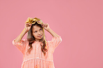 Wall Mural - Cute girl wearing carnival mask on pink background, space for text