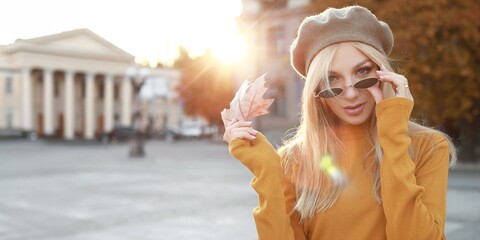 Wall Mural - Beautiful young woman in city on autumn day