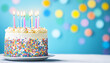 © Anastasiya - On a blue background a birthday cake decorated with rainbow sprinkles and burning candles on white and cream icing. The atmosphere is cozy and joyful, which is associated with birthday celebrations