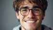 © Rstm - Closeup portrait of a smiling young man wearing glasses.