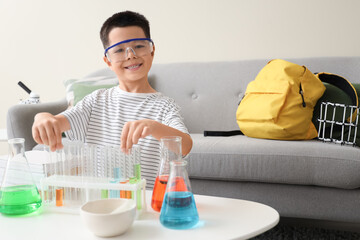 Wall Mural - Cute little boy with chemistry flasks at home