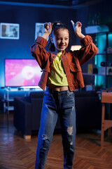 Lively child showcasing enchanting dance routine on social media platform, participating in online challenge. Cheerful youngster filming video in home studio for internet audience