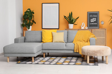 Sticker - Stylish living room with grey sofa, comfortable pouf and plaid