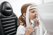 © Валерия Стоганенко - In a modern ophthalmology clinic, an ophthalmologist checks a little girl's vision using a binocular slit lamp. Advertisement for pediatric ophthalmology