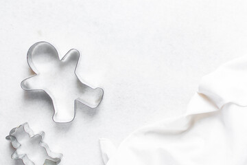 Top view of metal gingerbread cookie cutters on a marble countertop, gingerbread man cookie cutter, process of making gingerbread cookies