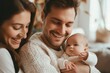 © miss irine - Happy man holds adorable baby girl. Smiling wife stands beside. European family portrait. Joyful moment of parenthood. Love, happiness shared among three people. Father, mother, baby together in