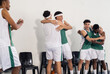 © Wavebreak Media - Celebrating victory, basketball team hugging and cheering on court sidelines