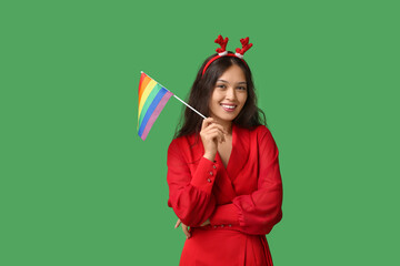 Poster - Young Asian woman in Christmas reindeer horns with LGBT flag on green background